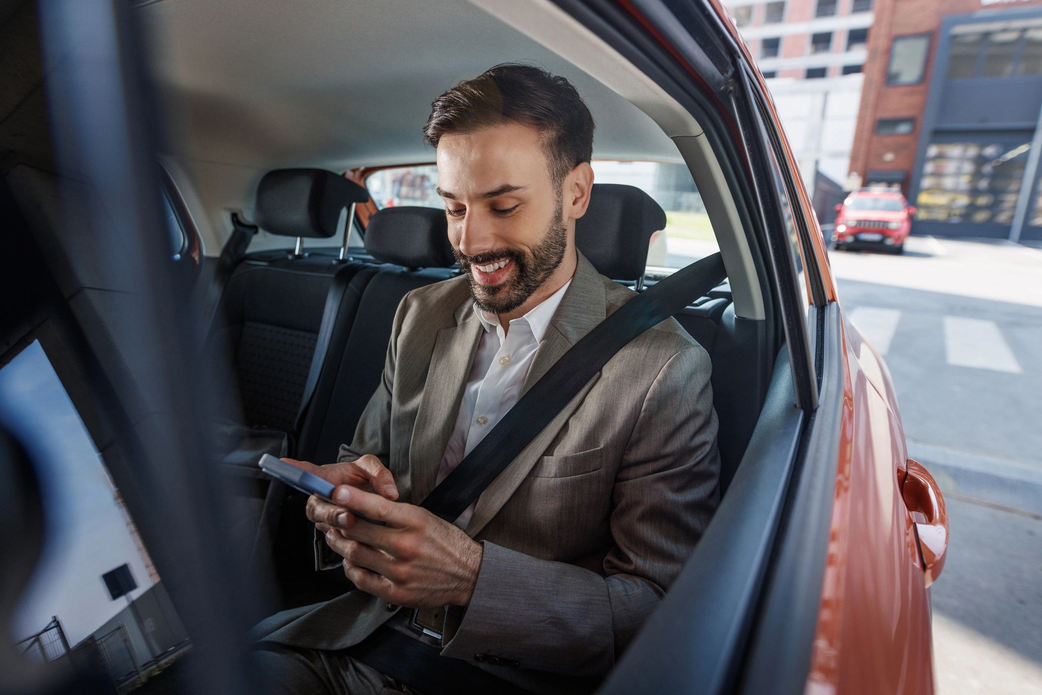 Executive passenger using a smartphone during a car journey
